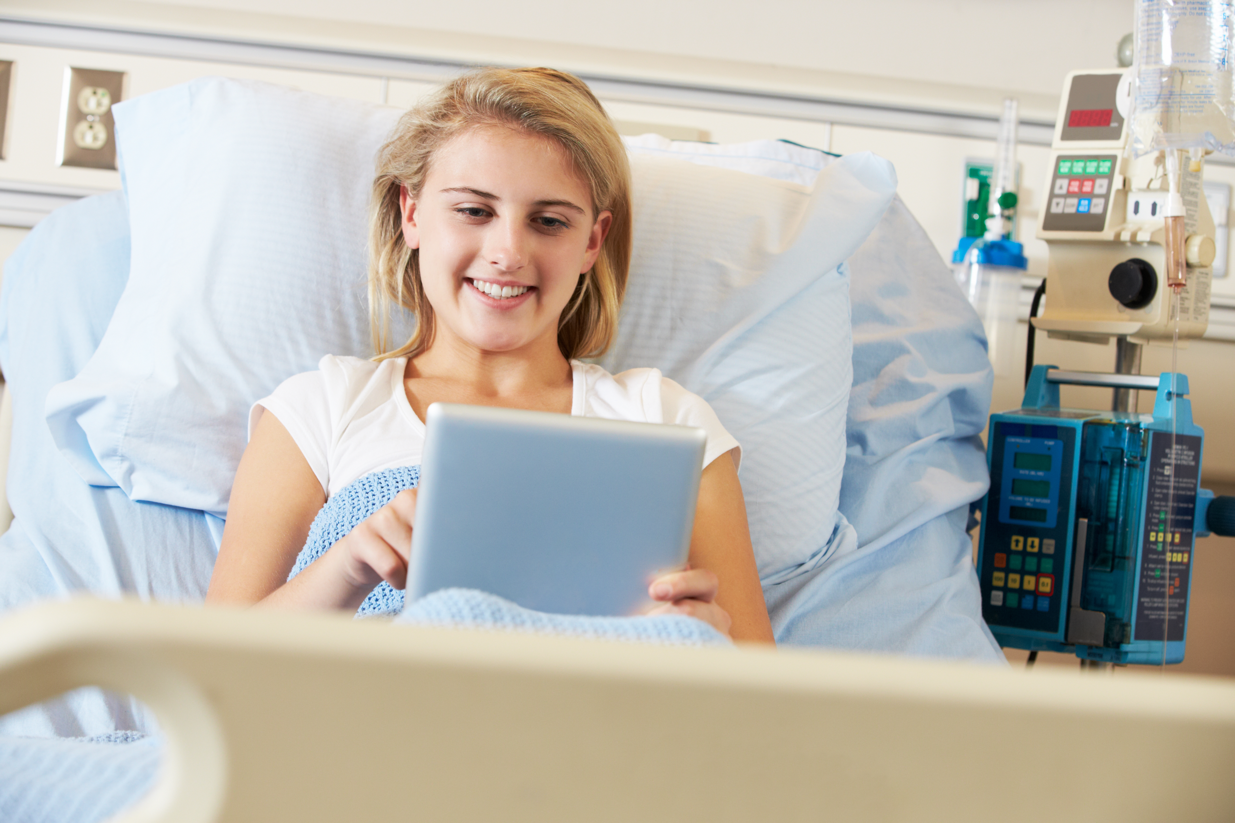 young smiling woman using a tablet in the hospital